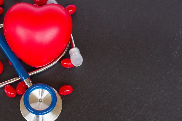 Estetoscopio con dos corazones rojos y pastillas — Foto de Stock