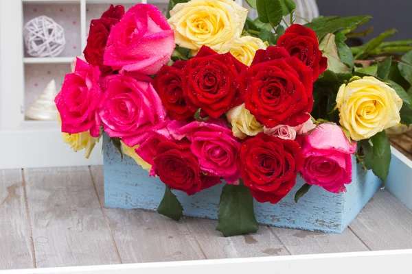 Rosas vermelhas, amarelas e rosa na mesa — Fotografia de Stock