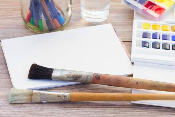 Vit canva med ram av färger och penslar — Stockfoto