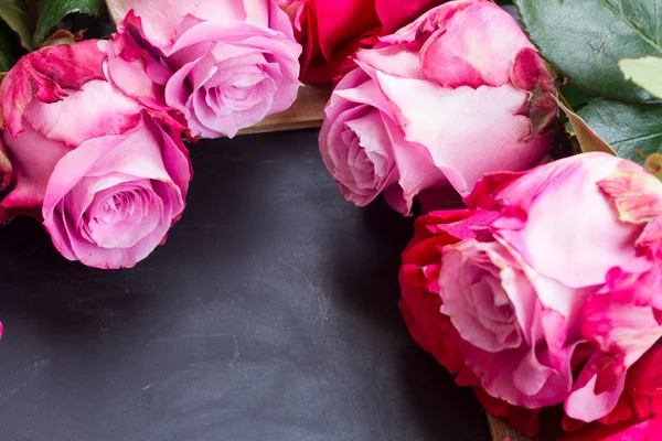 Rosas vermelhas e rosa na mesa — Fotografia de Stock