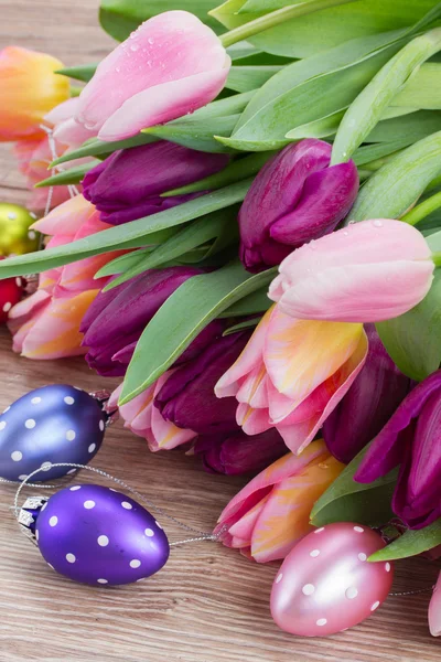 Розовые и фиолетовые тюльпаны с пасхальными яйцами — стоковое фото