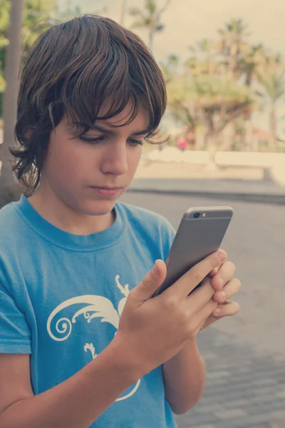 Мальчик со смартфоном на улице — стоковое фото