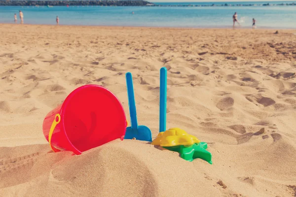 Juguetes de playa en arena en la orilla del mar — Foto de Stock