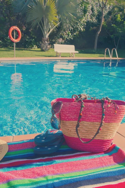 Toalha e acessórios de banho perto da piscina — Fotografia de Stock