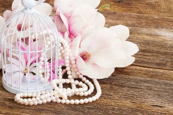 Fiori di magnolia con perle su tavola di legno — Foto Stock