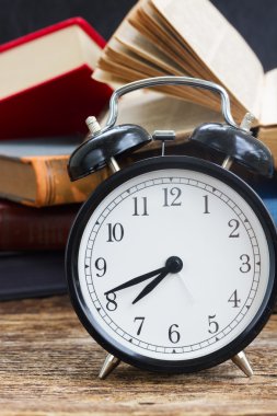 yığın kitap ile masa saati