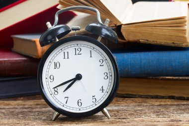 yığın kitap ile masa saati