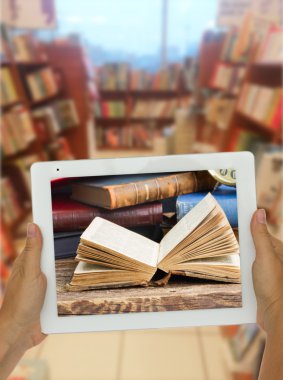 arka planda Kütüphane rafları ile tablet