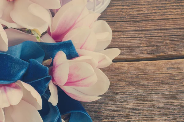 Magnolia blommor med pärlor på träbord — Stockfoto