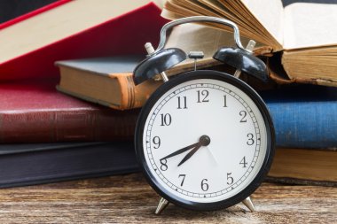 yığın kitap ile masa saati