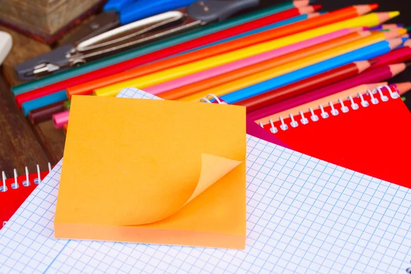 Pusty notatnik i zestaw kolorowe kredki na czarny deska — Zdjęcie stockowe