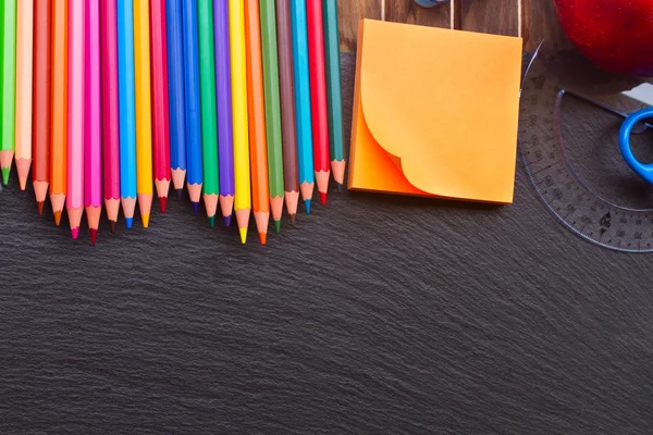 Uppsättning av färgglada pennor på svarta tavlan — Stockfoto