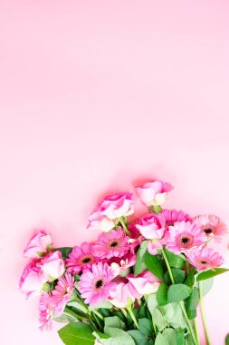 düğün ya da anneler günü geçmişi, pembe arka planda bir buket gül ve herberalar.