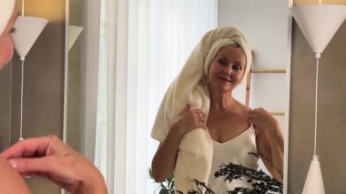 Neşeli bir kadın huzurlu, bitkisel banyosunda cilt bakımının keyfini çıkartıyor.