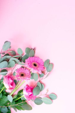 düğün ya da anneler günü geçmişi, gül buketi ve taze okaliptüs yapraklı otlar pembe arka planda.