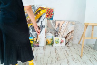 Bir sanatçı, geniş ve iyi ışıklandırılmış bir sanat stüdyosunda tutkuyla güzel bir çiçek başyapıtı yaratıyor.