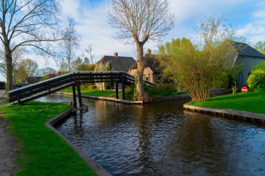 Hollanda 'nın kırsal kesimlerinde eski küçük bir kasaba olan Giethoorn' da kanallar ve köprüler, Hollanda manzarası
