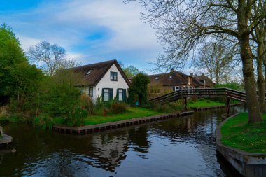 Hollanda kırsalının geleneksel küçük bir kasabası. Giethoorn, Hollanda 'da kanal ve köprü manzaralı.