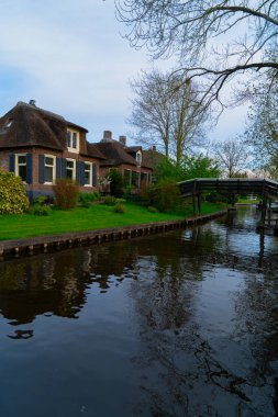 Hollanda kırsalının geleneksel küçük bir kasabası. Giethoorn, Hollanda 'da kanal ve köprü manzaralı.
