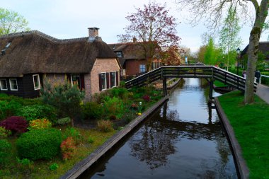Hollanda 'nın kırsal kesimlerinde eski küçük bir kasaba olan Giethoorn' da kanallar ve köprüler, Hollanda manzarası