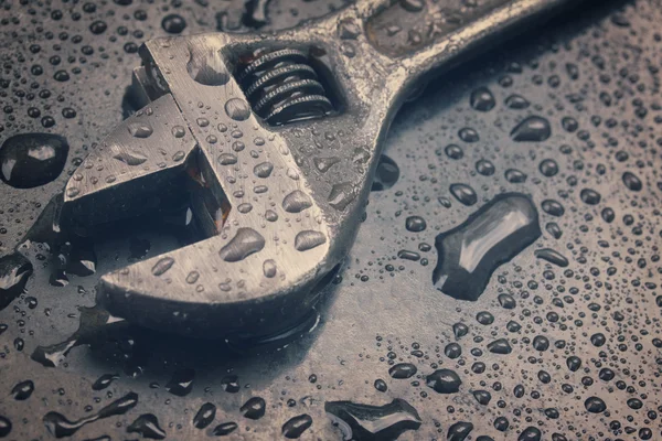 Adjustable spanner in water drops close up — Stock Photo, Image
