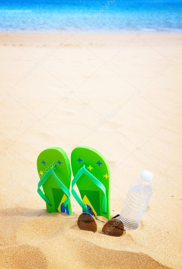 green sandals on sandy beach