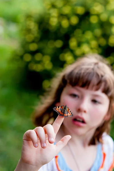 A menina olha para uma borboleta. Aglais urticae L . — Fotografia de Stock