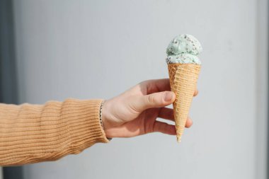 Dondurma külahı yayılmış erkek elinde.