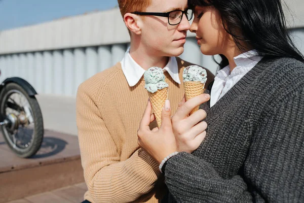 Pareja sensual sentada al aire libre, sosteniendo helado, besando —  Fotos de Stock