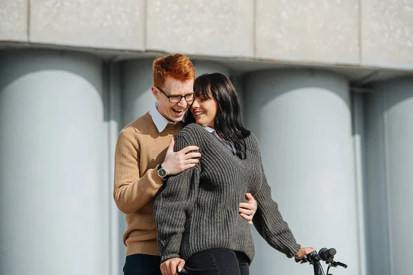Mükemmel bir çift, bisikletli kız arkadaşını kucaklayan genç bir adam, o da sarılıyor. — Stok fotoğraf