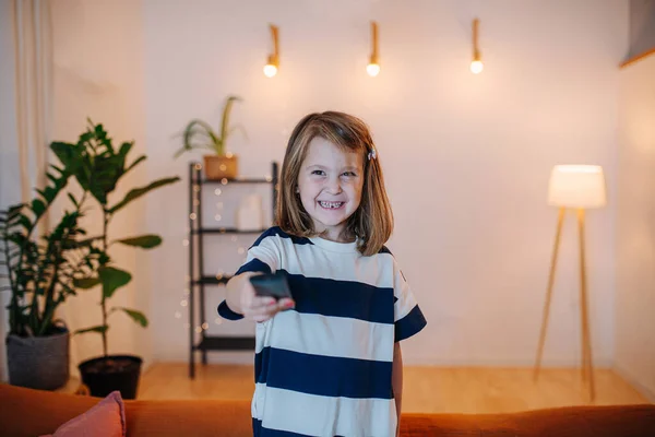 Petite Fille Joyeuse Changer Chaîne Télévision Avec Une Télécommande Dans — Photo