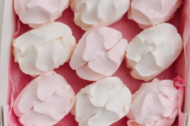 Alternatif pembe ve beyaz çift katmanlı bir Zefir 'in pembe bir kumaş parçasındaki görüntüsünü kapat. Üst görünüm.