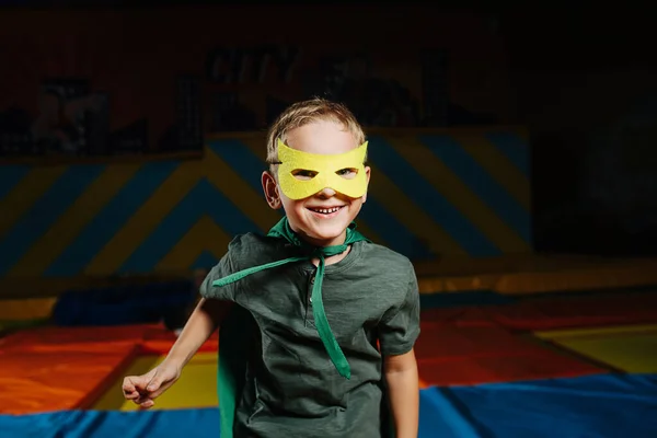Happy confident boy in mask in entertainment center on trampoline — ストック写真