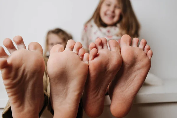 Piedi da bambino vicino alla telecamera. I loro volti sfocati su uno sfondo. — Foto Stock