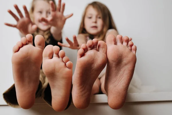 Los pies de los niños se acercan a la cámara. Sus rostros borrosos en un fondo. — Foto de Stock