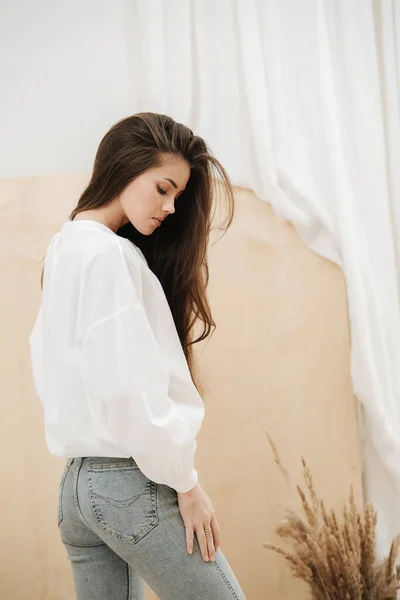 Reflective beautiful woman wearing tight jeans and white shirt. — Stock Photo, Image