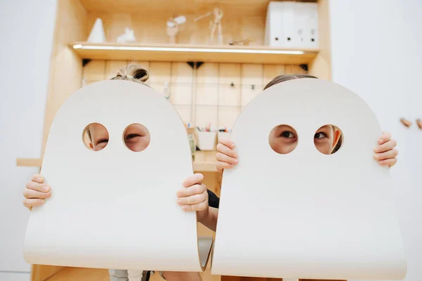 Les enfants jouent à la maison, regardent à travers les trous dans les chaises — Photo