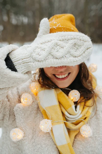 Lächelndes Mädchen an Heiligabend, das seine Augen mit einem Handschuh bedeckt — Stockfoto