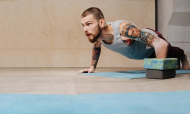 Çözülmüş genç engelli adam eğitimi, engellerin yardımıyla şınav çekmek.