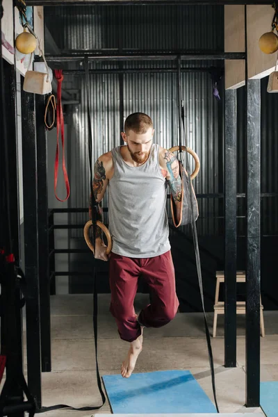 Gehandicapte armloze man training in de sportschool, opknoping aan gymnastische ringen — Stockfoto