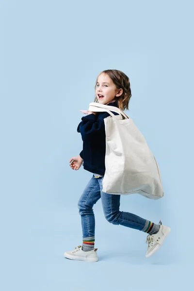 Petite fille gaie avec un grand sac à provisions de chiffon fonctionne — Photo