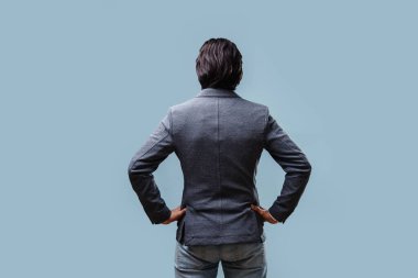 Ceketindeki işadamı ellerini kemerine bağladı, arkadan manzara.