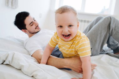 Küçük gülen çocuk babamı yatak odasında uyandırdı.