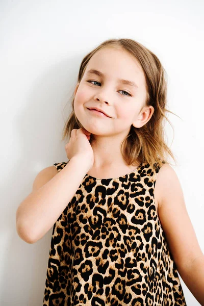 Retrato de una niña de ojos azules en un vestido estampado de leopardo — Foto de Stock