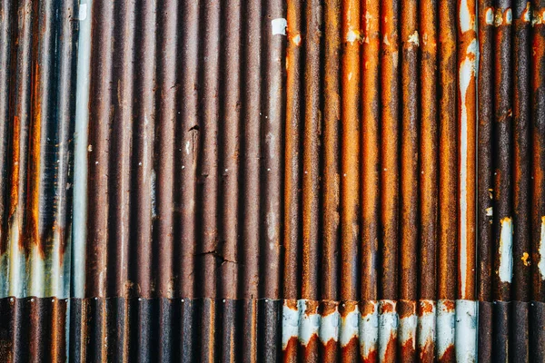 Rusty gebarsten gegolfd metalen wand, bestaande uit kleine vellen. — Stockfoto