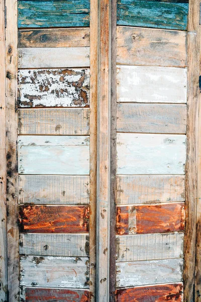 Gekleurde houten planktegeldeuren met schilferende verf. In verticale rijen — Stockfoto