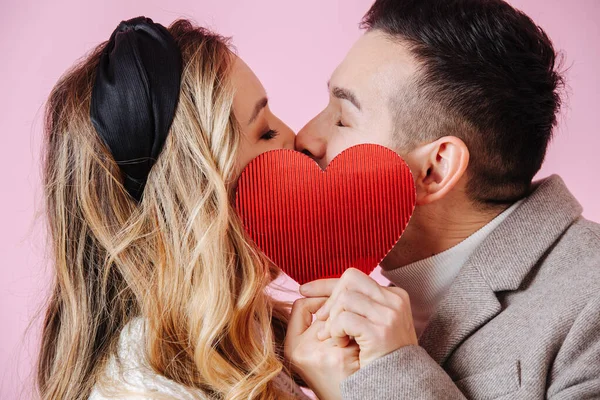 Día de San Valentín. primer plano beso oculto por rojo corazón —  Fotos de Stock