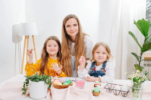 Mutter und ihre beiden Töchter posieren für ein Foto, alle bemalen Ostereier — Stockfoto