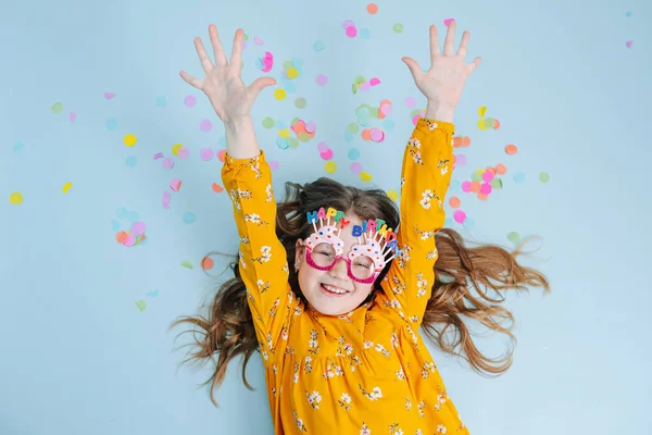 A menina de aniversário alegre está em um soalho, as mãos estendidas — Fotografia de Stock