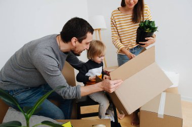 Yeni eve taşınma ve eşyaları yerleştirme. Baba ve anne oğullarına yardım ediyor.